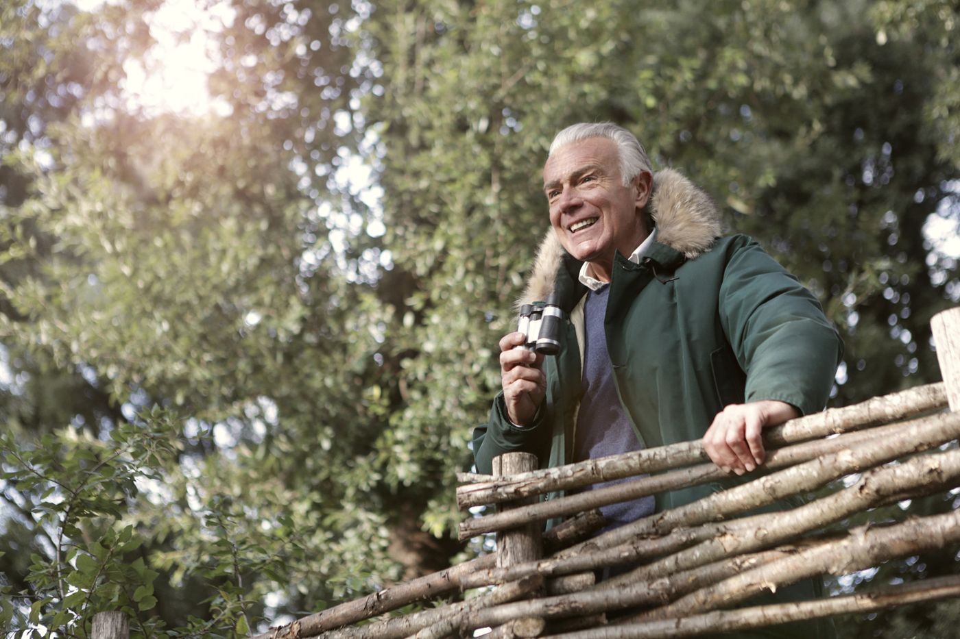 Senior man laughing outdoors, looking off to the side — stock photograph