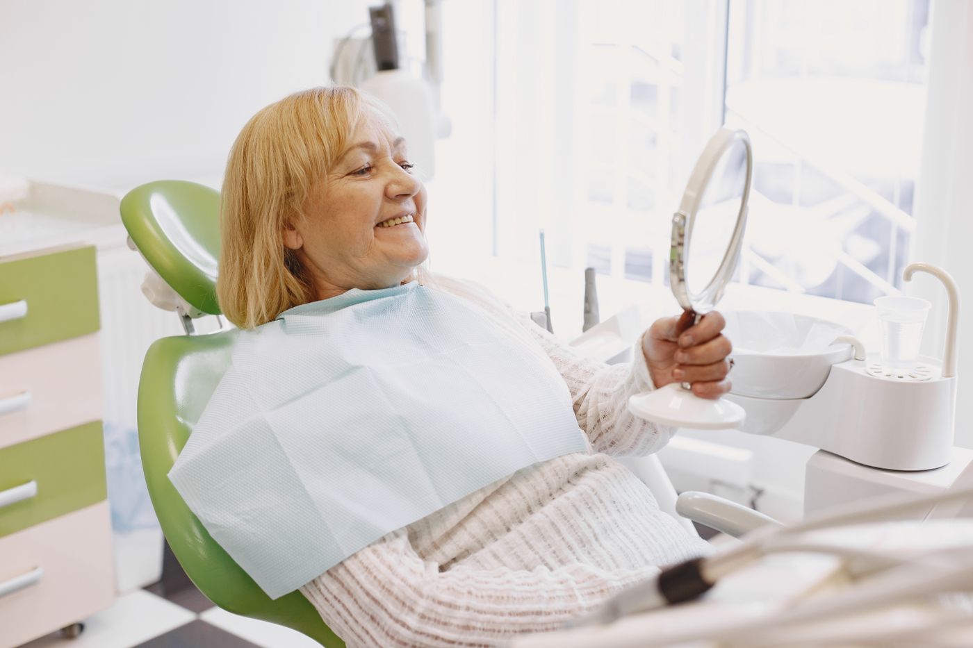 Clinician with a smiling patient in a dental practice — stock photograph