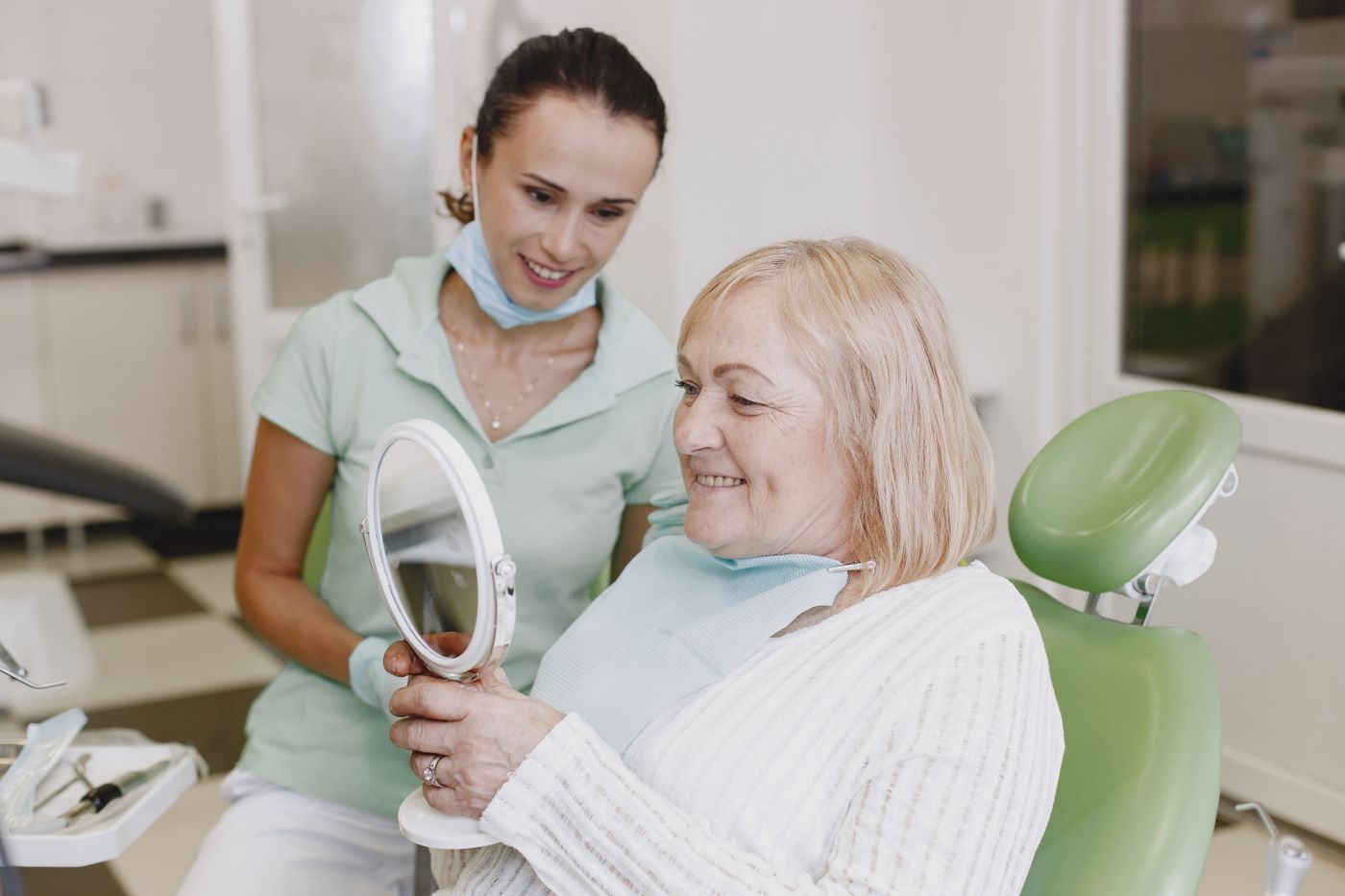 Clinician with a smiling patient in a dental practice — stock photograph