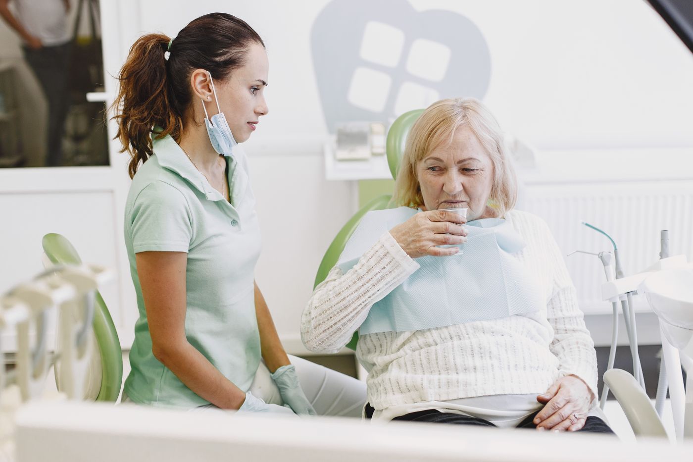 Clinician with a smiling patient in a dental practice — stock photograph