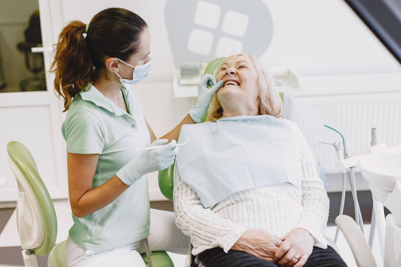 Clinician with a smiling patient in a dental practice — stock photograph